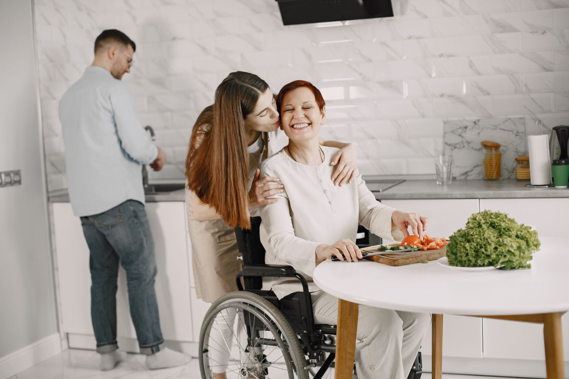 a family member tenderly supporting a loved one who uses a power wheelchair at home