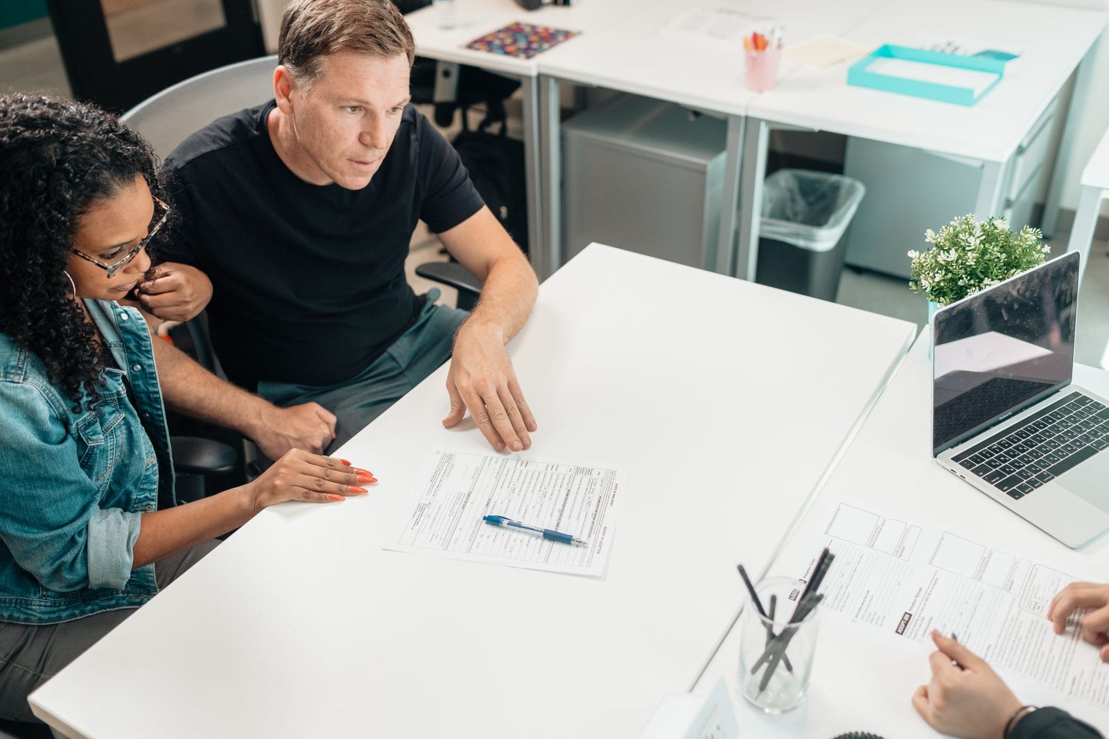 Couple reviewing disability case documents with a lawyer in an office.