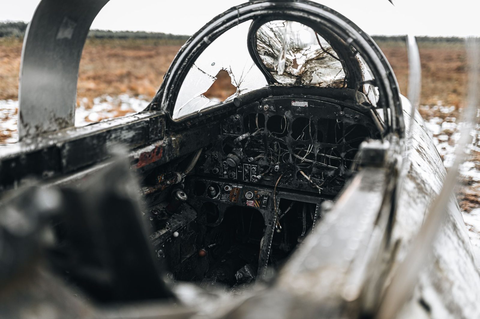 Destroyed aircraft cockpit in snowy wreckage.