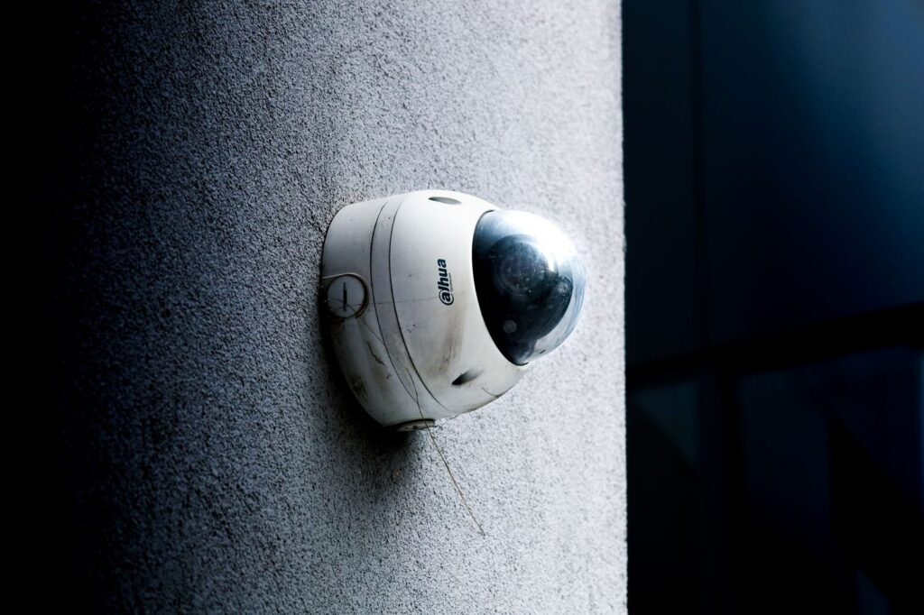 Dome security camera mounted on concrete wall for surveillance monitoring.