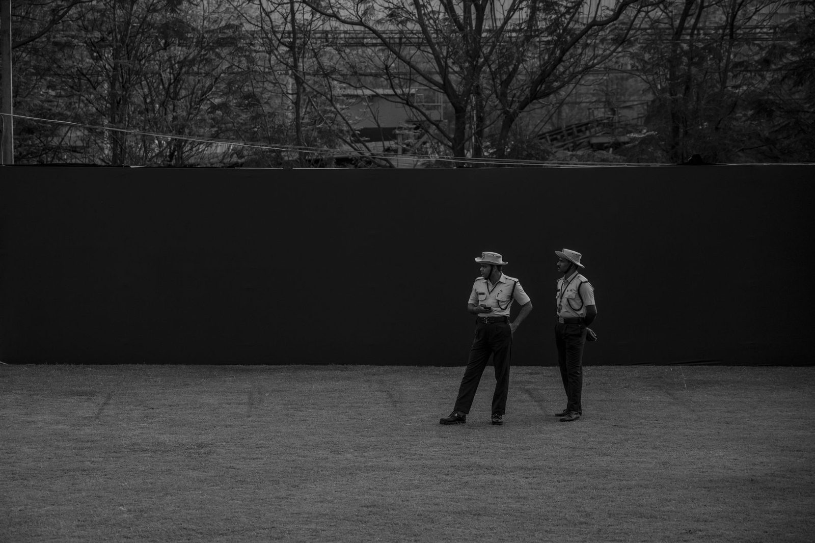 Dos guardias de seguridad uniformados de pie en el exterior.
