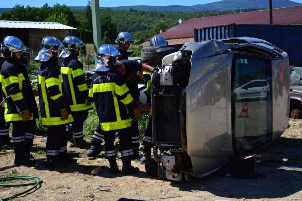 a forensic accident reconstruction team documenting skid marks and vehicle positions at a cordoned-off intersection after a catastrophic collision
