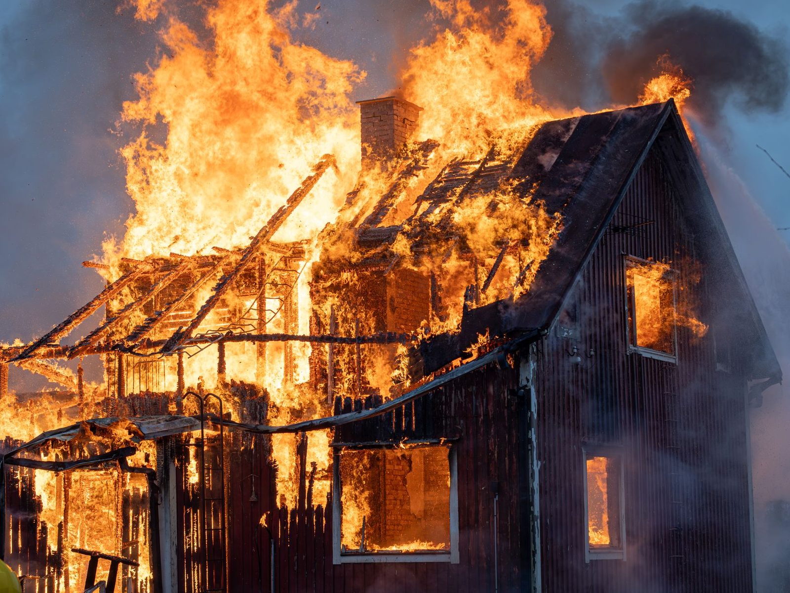 House engulfed in flames and smoke from a catastrophic fire.