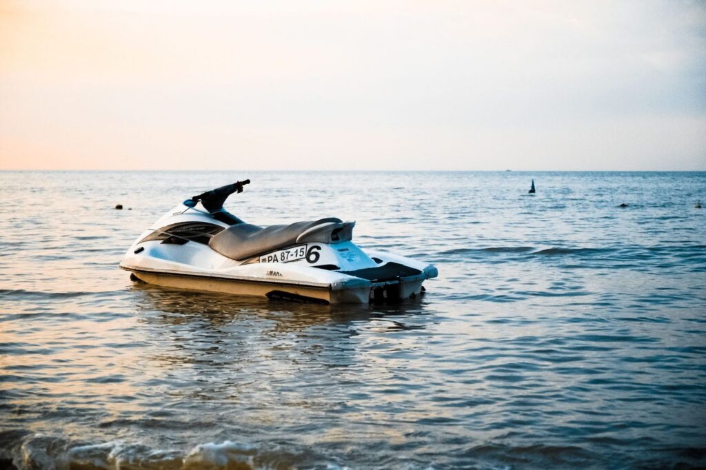 Jet ski on calm ocean water at sunset.