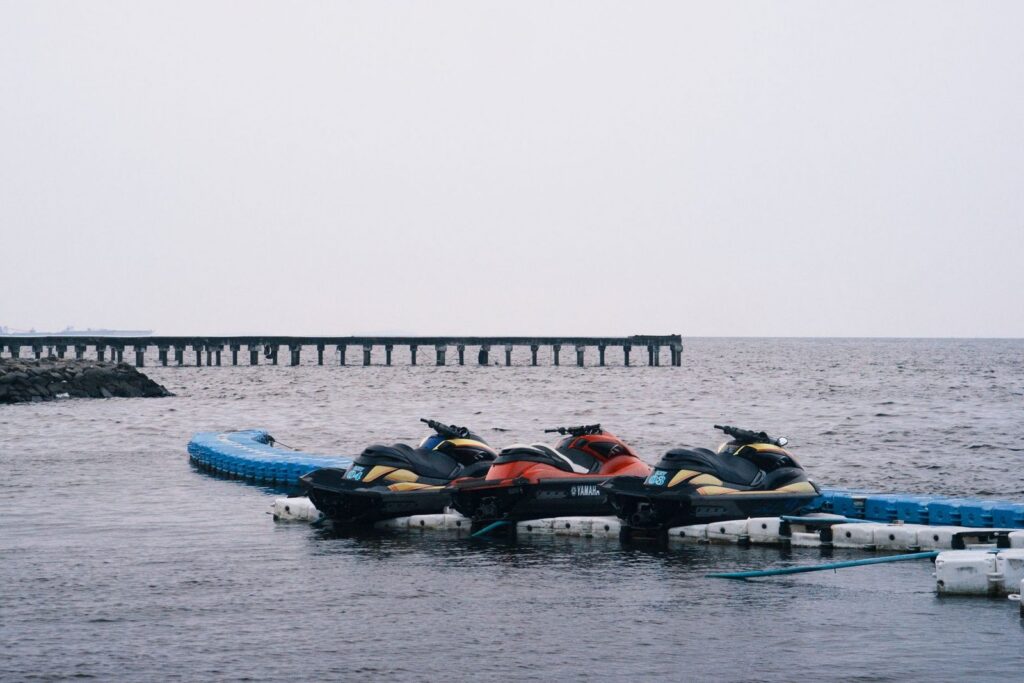 Jet skis docked at a coastal marina on a calm day.