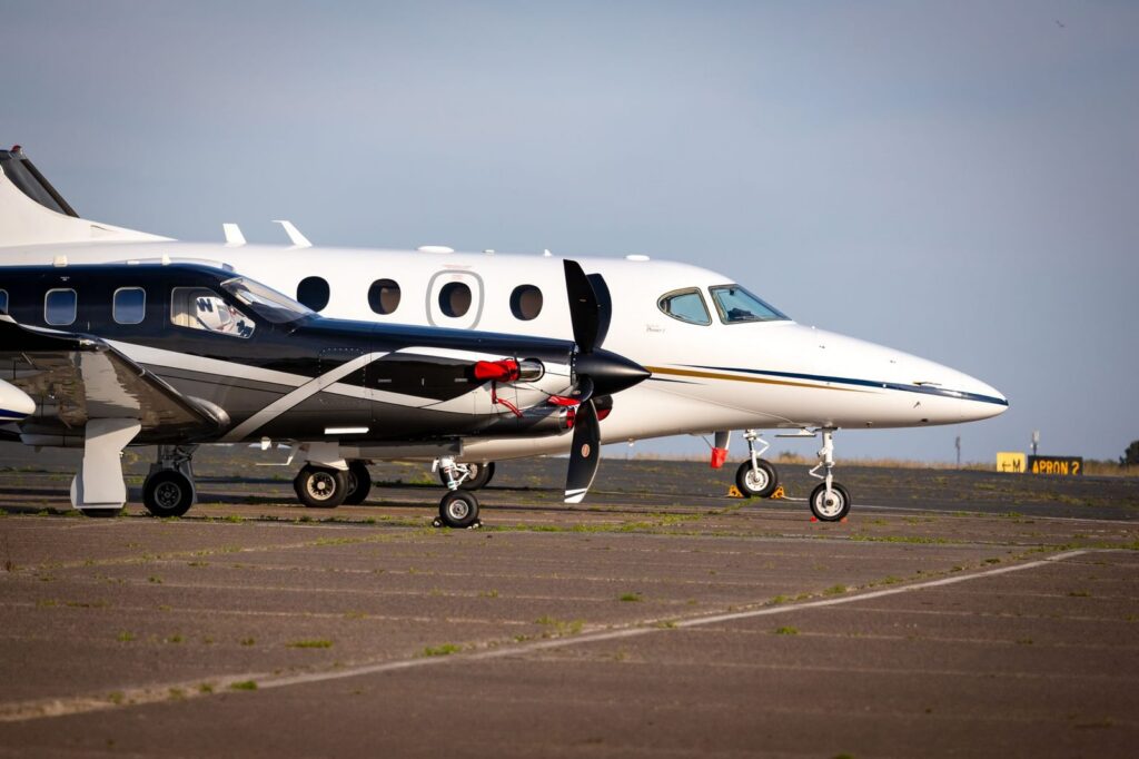 Luxury private jet on airport tarmac under clear skies.