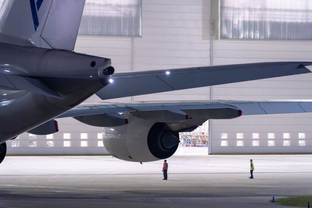 Maintenance crew inspecting airplane in hangar.
