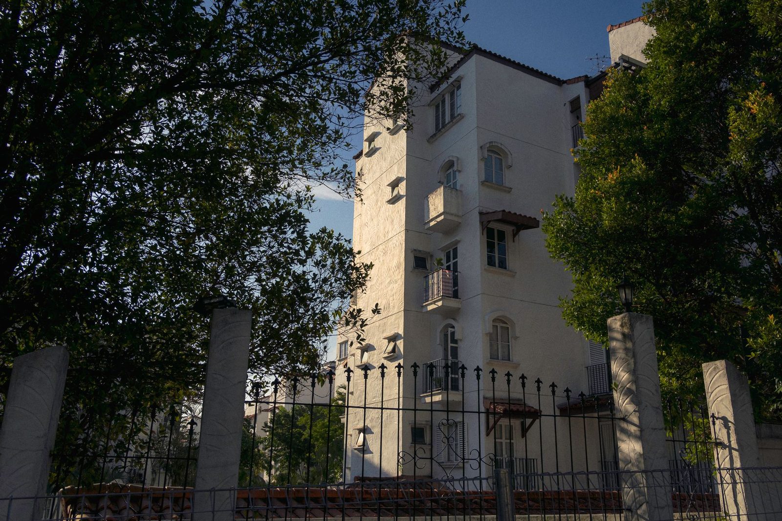 Modern apartment building exterior with surrounding trees in urban setting.
