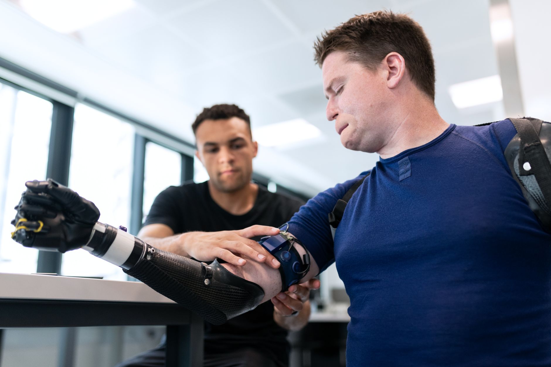 Prosthetist fits a patient with a high-tech prosthetic arm in a modern healthcare facility.