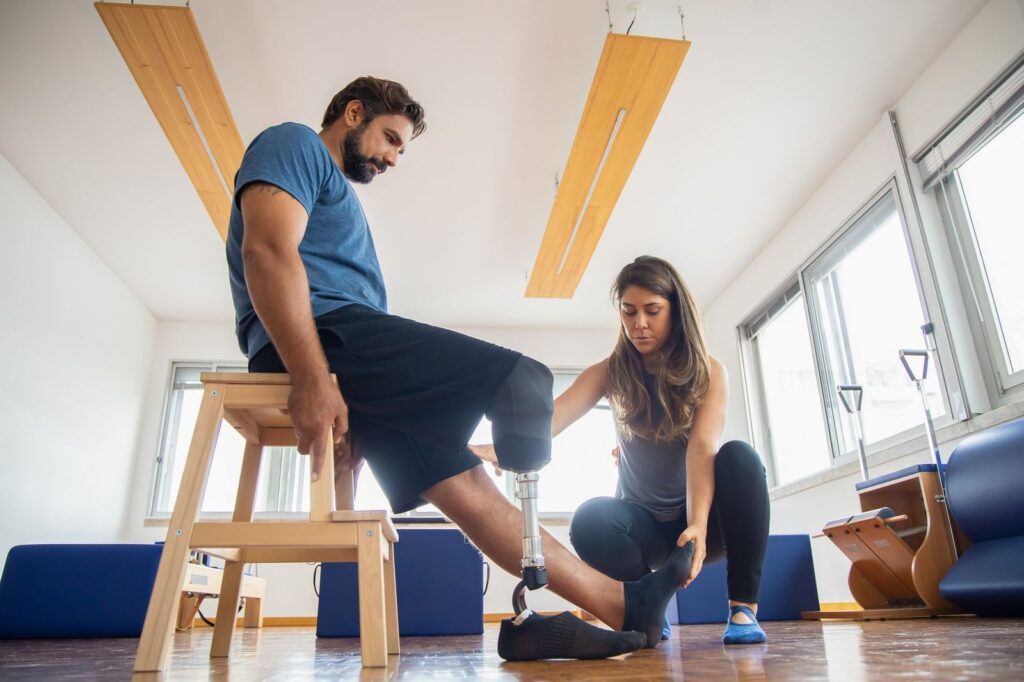 an amputation rehabilitation specialist fitting a comfortable prosthetic limb in a bright clinic