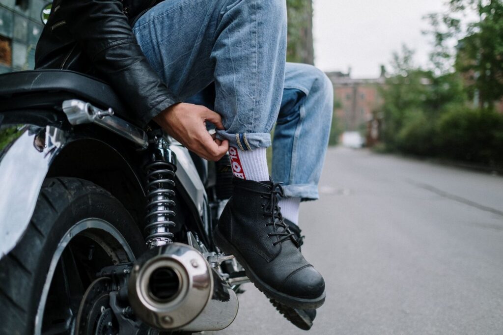 a rider with a prosthetic leg confidently returning to independent daily mobility beside a parked motorcycle after a catastrophic crash