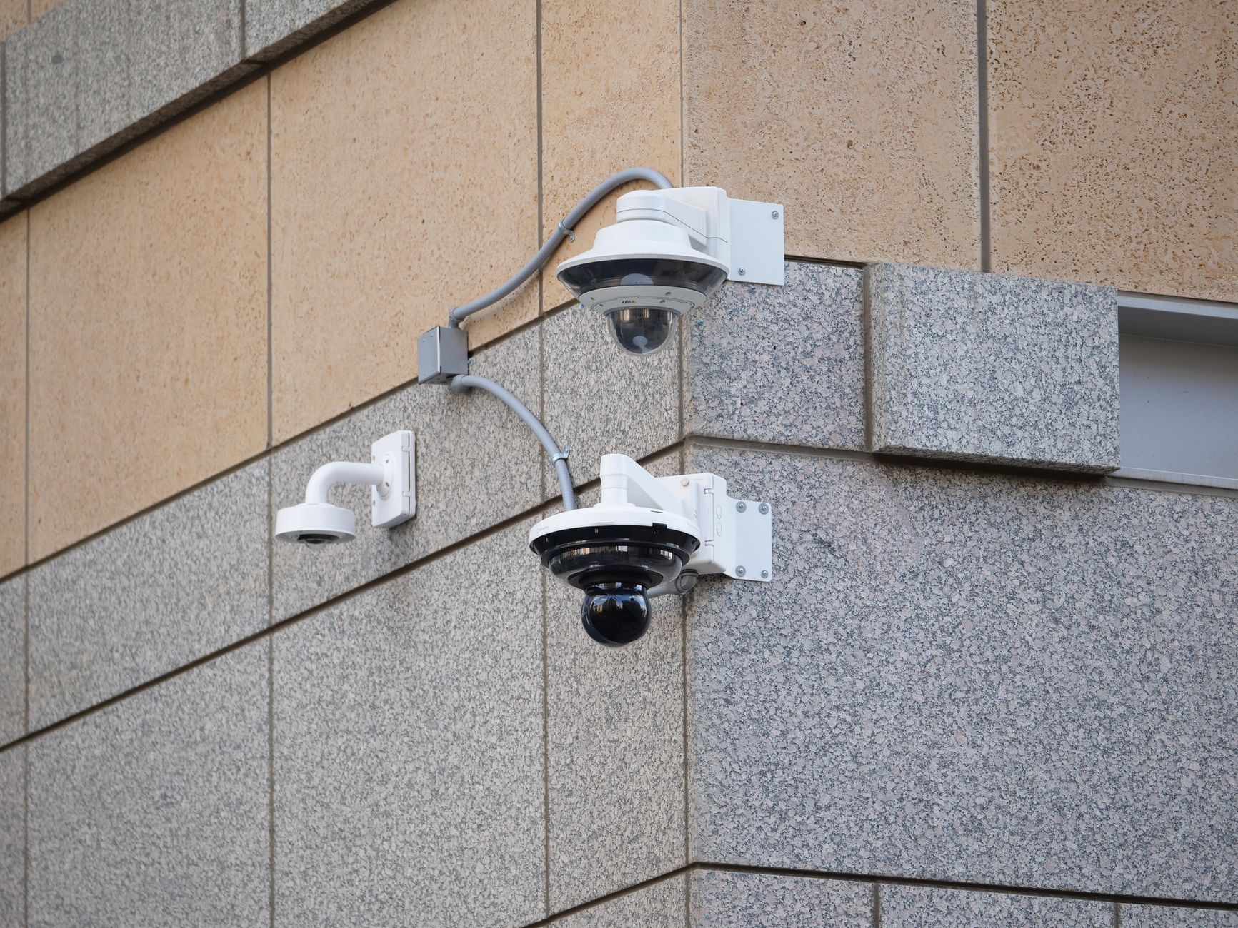 Security cameras mounted on a building wall for surveillance and safety.