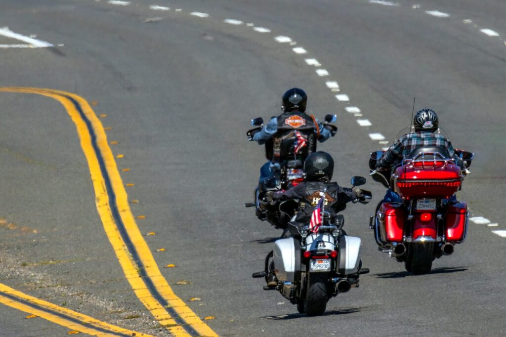 Three motorcyclists riding on an open highway.