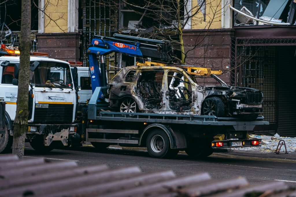 Auto quemado siendo remolcado en calle tras ataque en propiedad ajena.