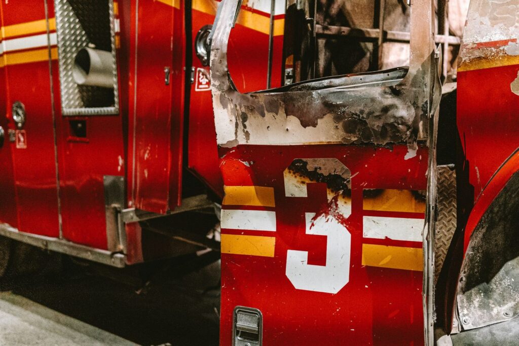 Burned fire truck door with number three, charred from vehicle fire.
