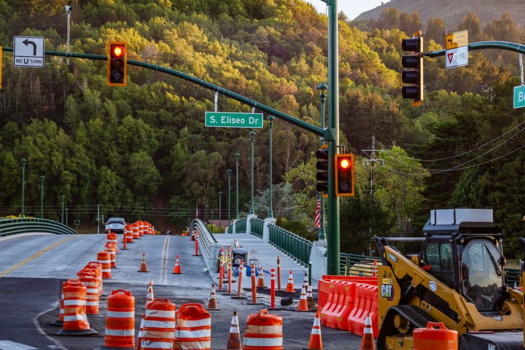 Busy road construction zone with traffic lights and warning signs on S. Eliseo Drive.