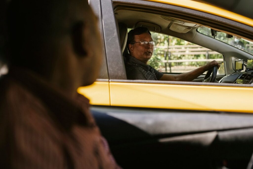Conductores de rideshare conversando en sus vehículos durante el trabajo.