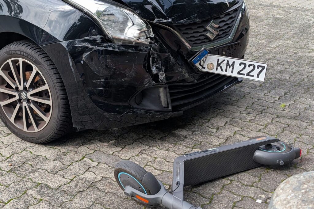 Damaged car and scooter after urban collision accident.