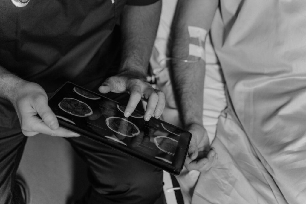 Doctor examines CT brain scans on tablet to assess head injury.