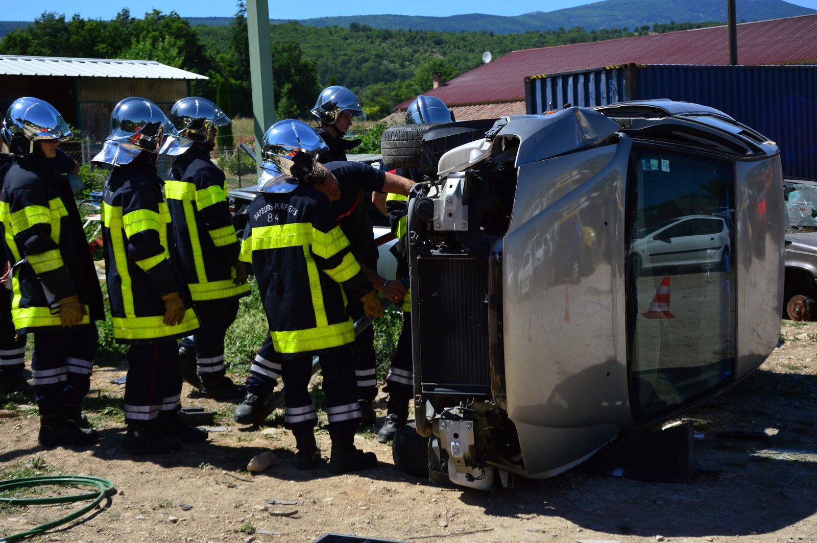 Firefighters responding to an overturned vehicle at a crash scene.