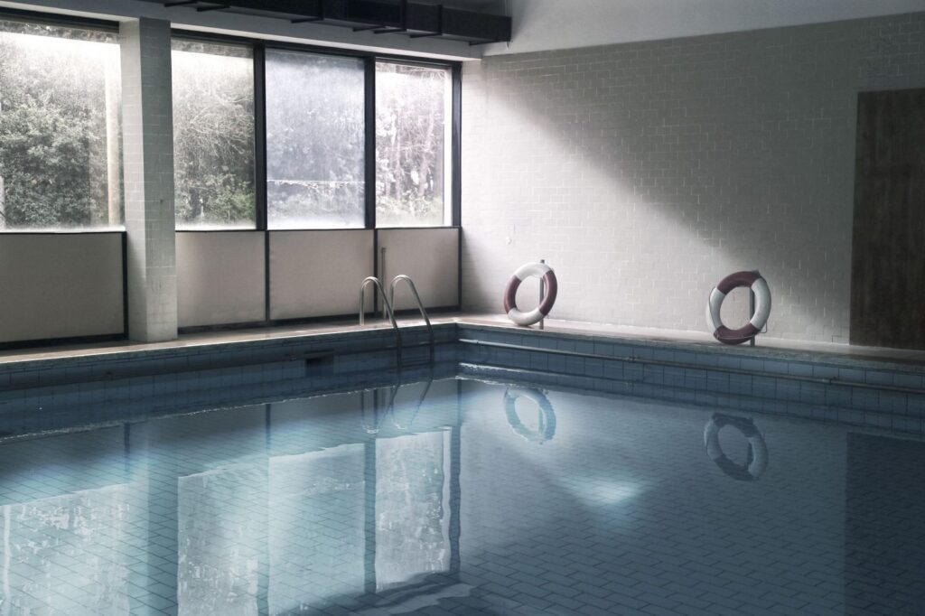 Indoor swimming pool with life rings and windows.
