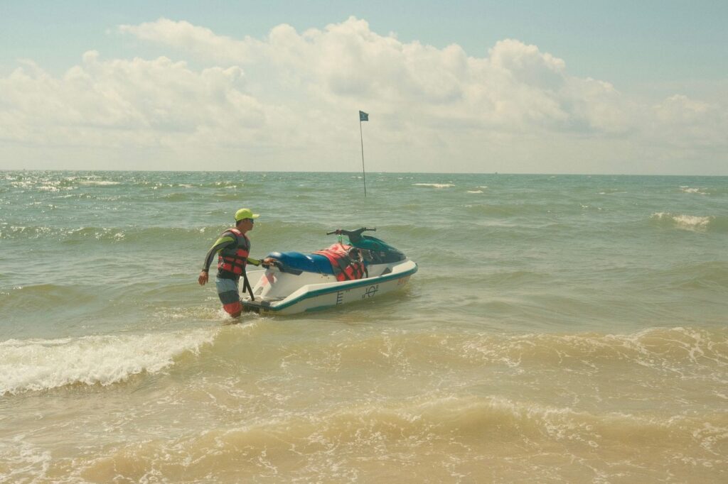 Man towing jet ski on Florida beach on sunny day.