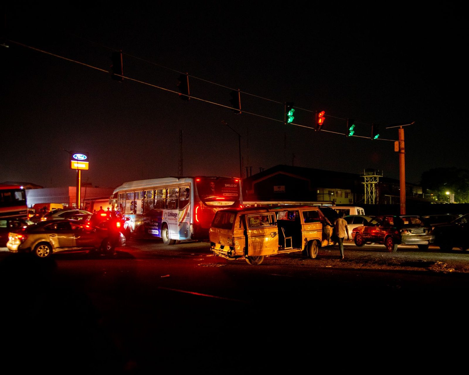 Nighttime traffic accident at busy urban intersection with multiple vehicles.