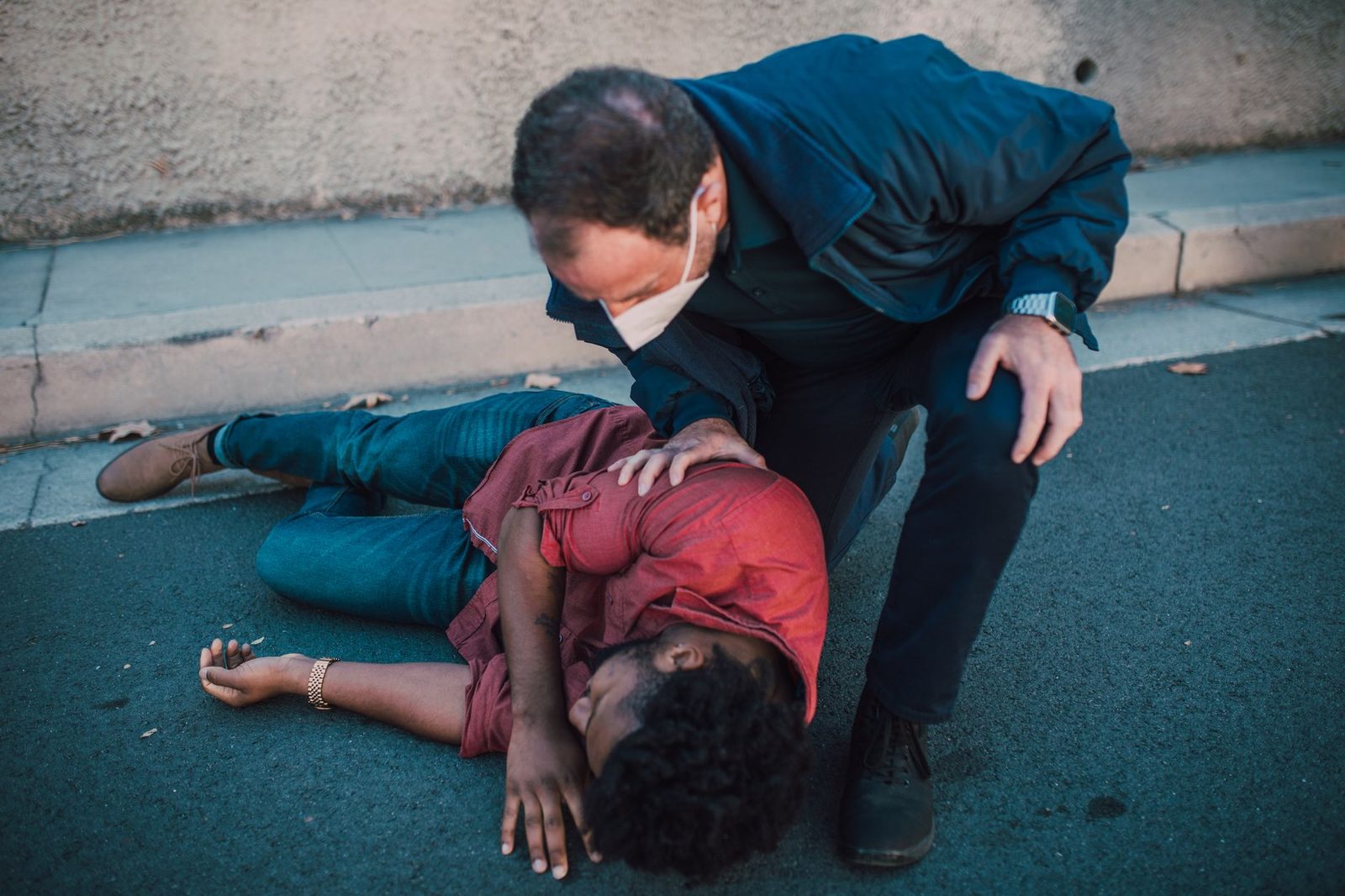 Paramedic providing emergency care to an injured person on the roadside.