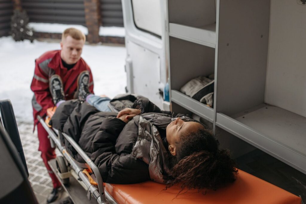 Paramedics loading a burn injury patient into an ambulance for emergency transport.