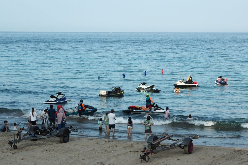 Personas disfrutando de esquí acuático en una playa soleada.