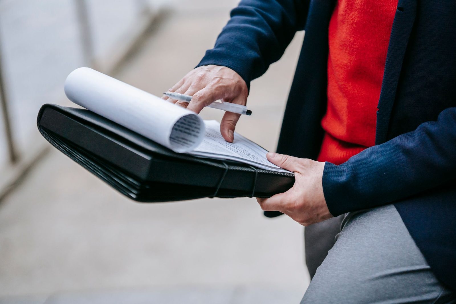 Professional reviewing legal documents outdoors at a desk.