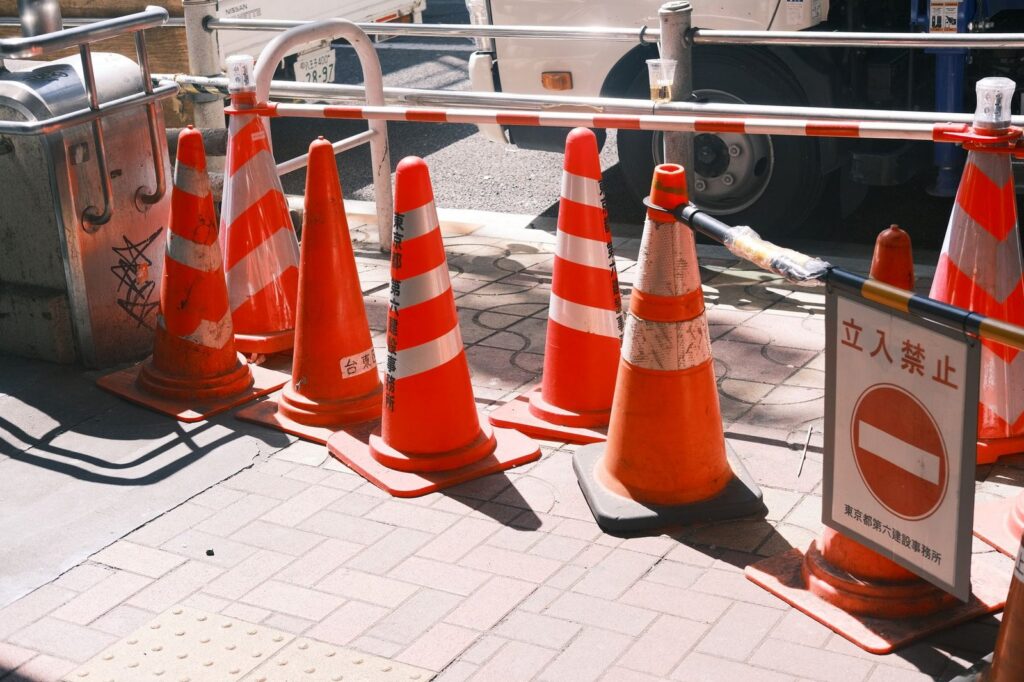 Red traffic cones and no entry sign blocking a construction site.