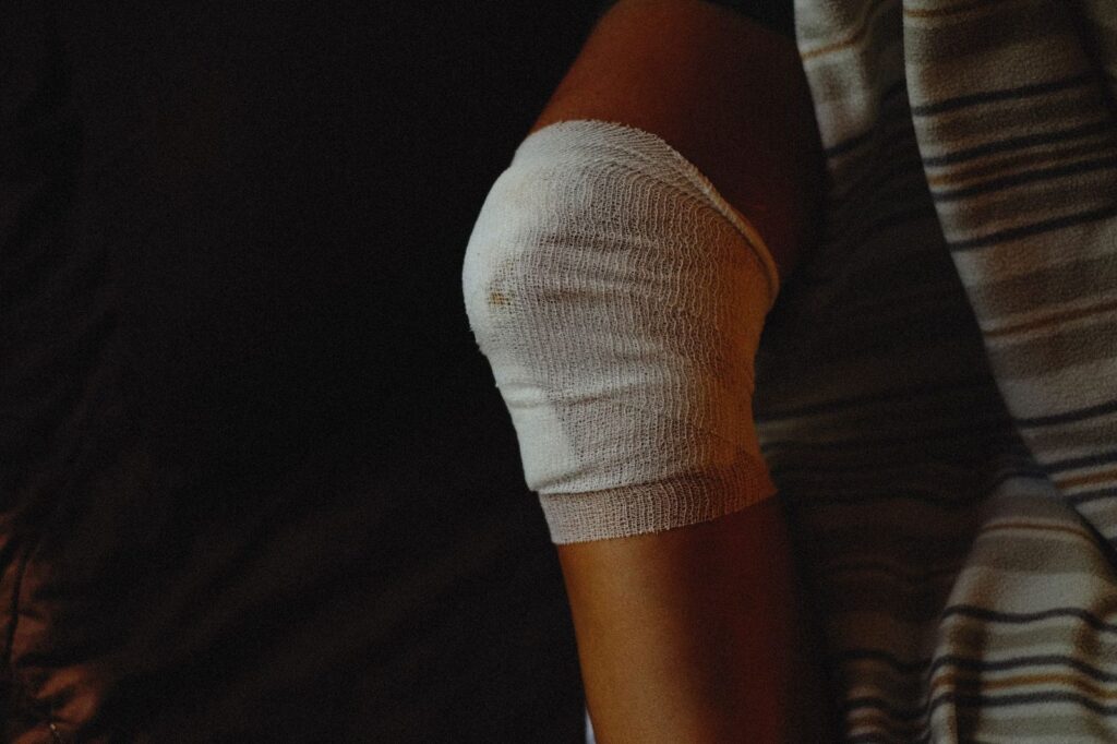 Rodilla vendada mostrando cuidado y proceso de cicatrización después de lesión.