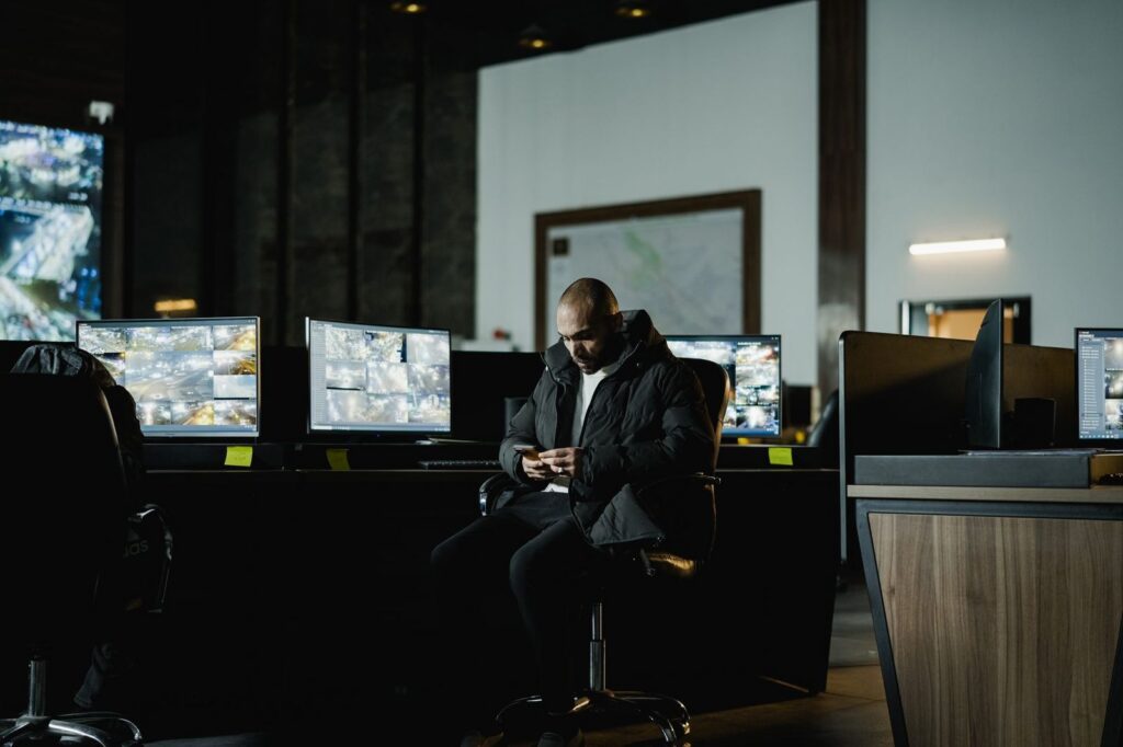 Security officer monitoring surveillance screens in control room.