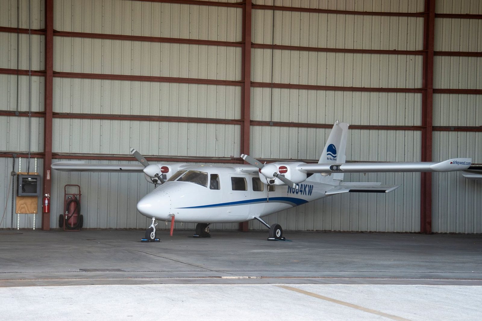 Small white airplane parked in aircraft hangar in Key West, Florida.
