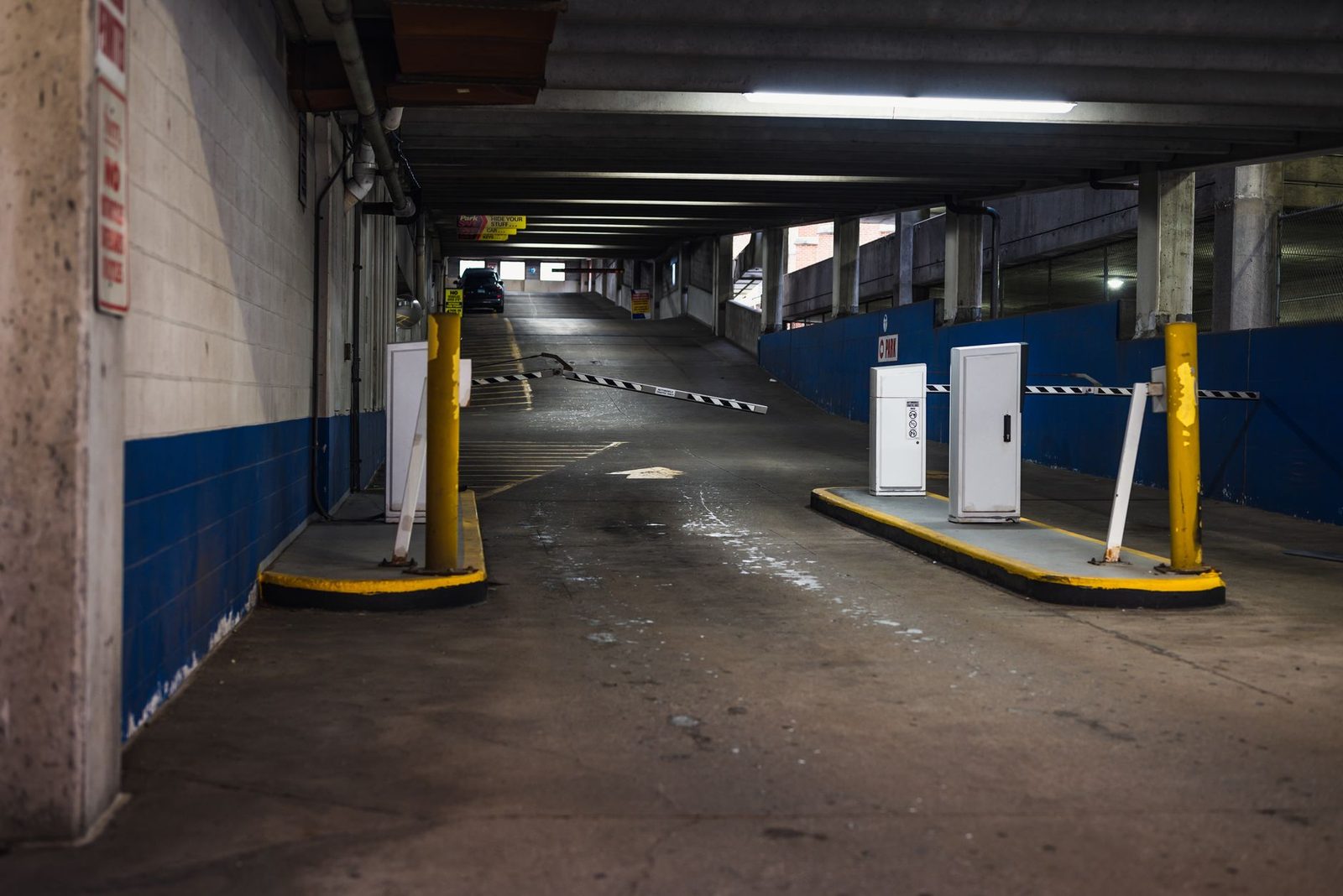Underground parking garage entrance with dim lighting and barriers.