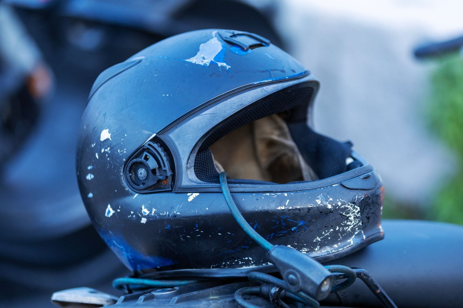 Worn motorcycle helmet with visible scratches and damage.