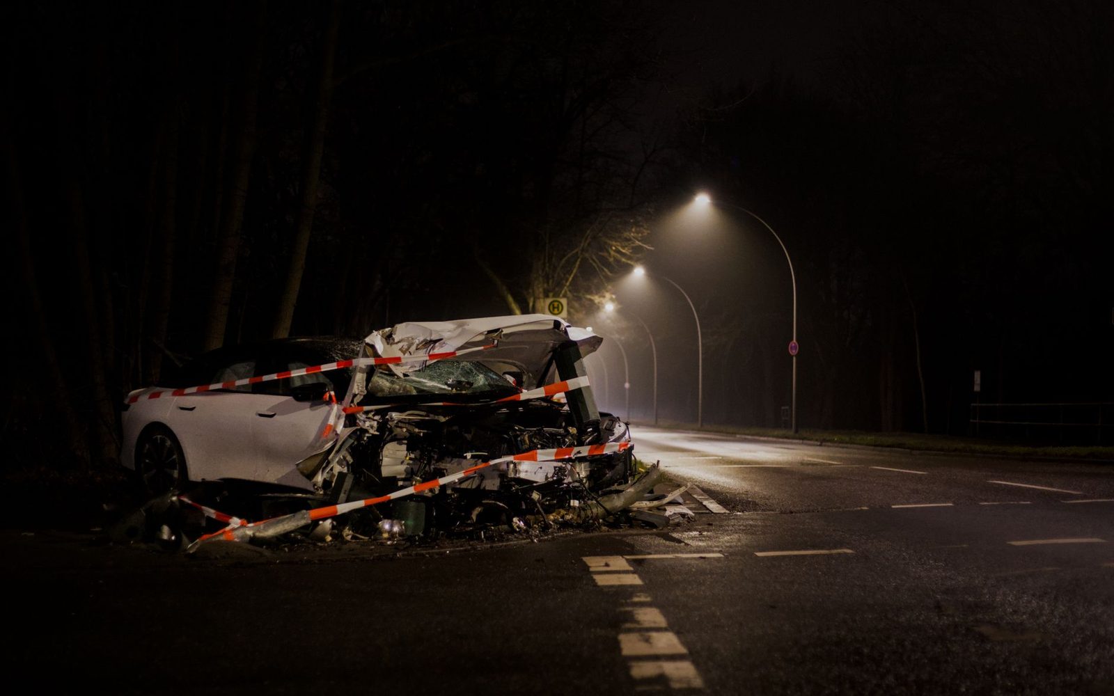 Wrecked car on a dark street at night after a collision.