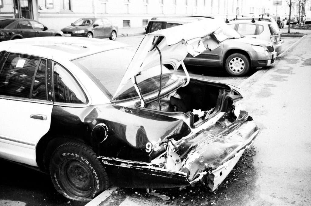 Wrecked car with severe damage on urban street.