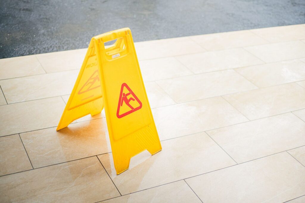 Yellow wet floor caution sign on tile flooring.