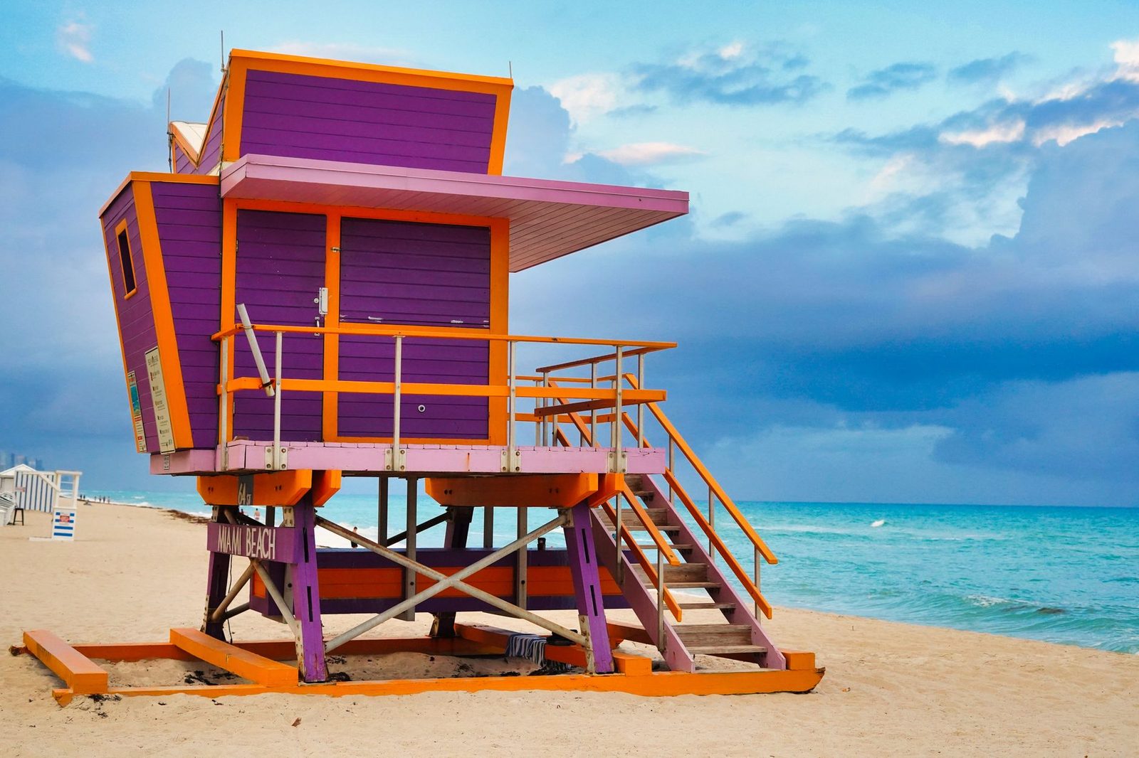 Colorful lifeguard tower on Miami Beach under a dramatic ocean sky.
