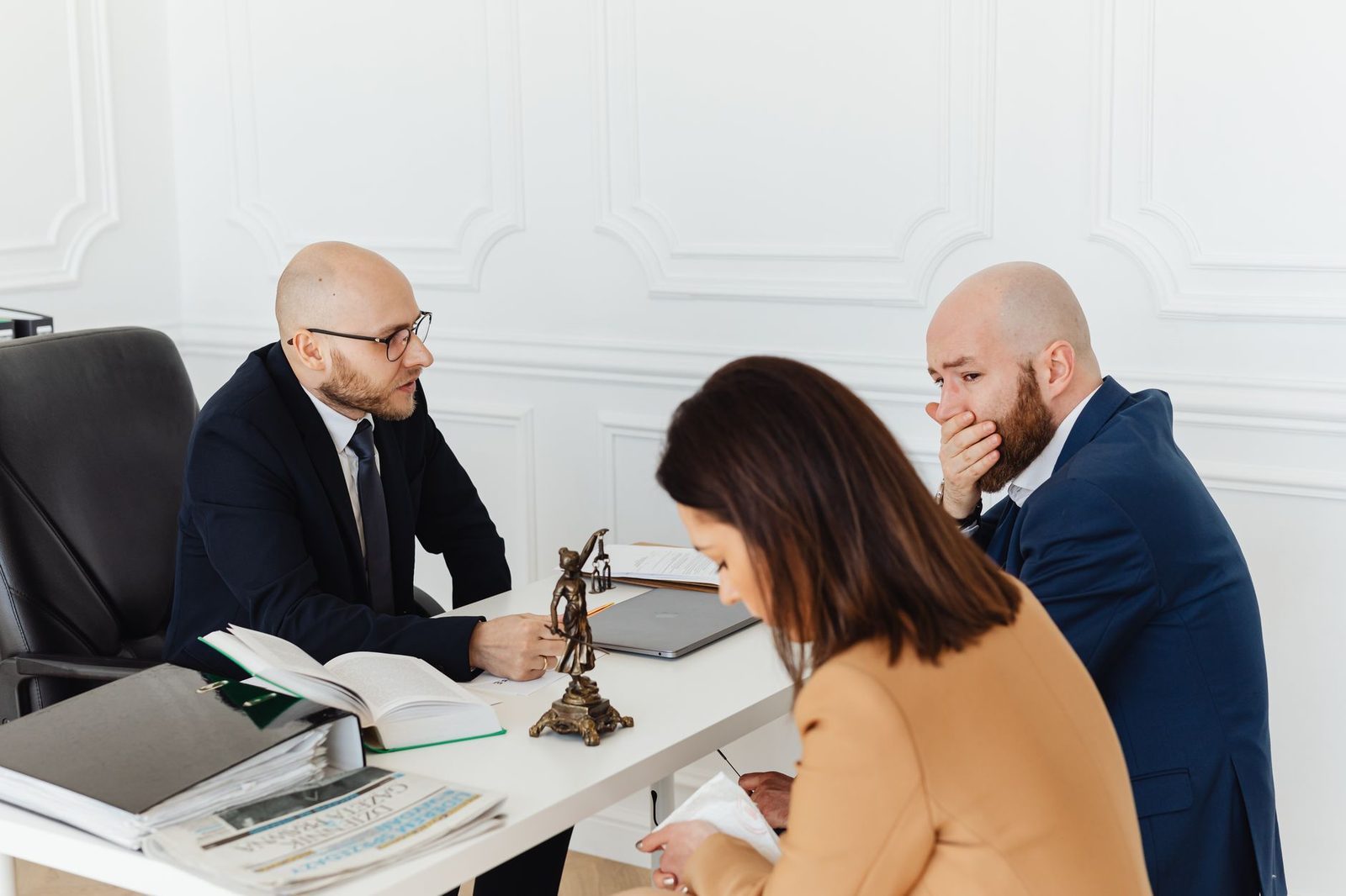 Consulta legal profesional entre abogado y clientes en oficina.