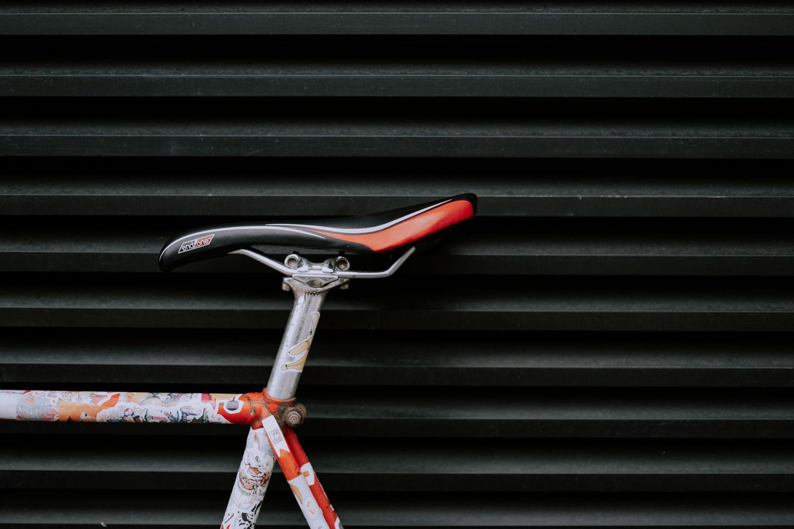 Modern bicycle seat against geometric patterned wall.
