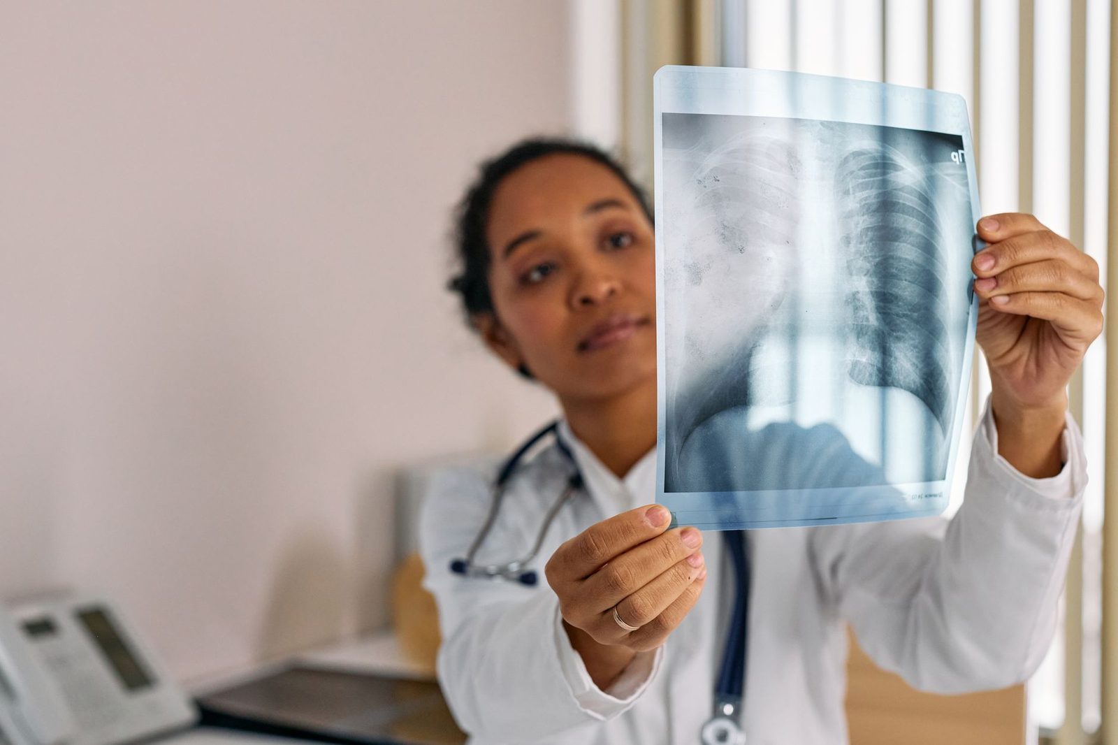 A healthcare professional reviews a chest X-ray on a screen in a modern medical office.