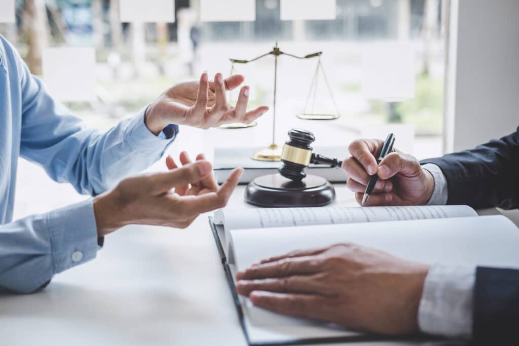 Clients discussing legal matters with a gavel in foreground