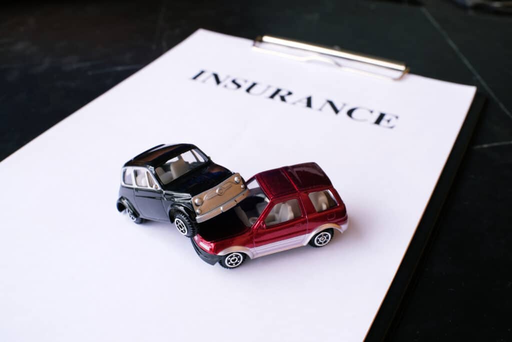 two toy car on insurance paper