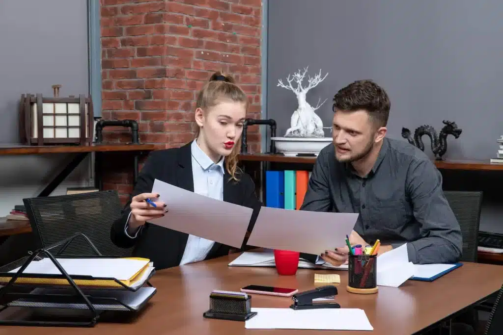 Two professionals reviewing a document in an office