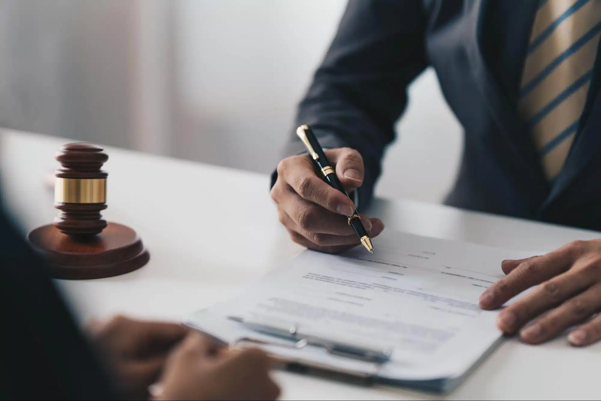 Signing legal documents near a judge's gavel