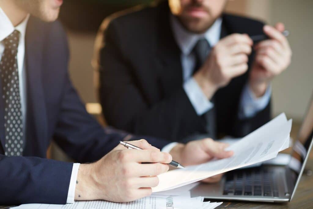 Businessmen discussing documents at a desk